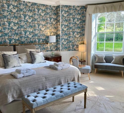 a bedroom with two beds and a couch and a window at Burleigh Court Hotel in Stroud