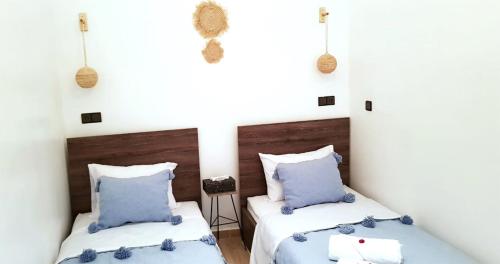 a bedroom with two beds with blue pillows at Dar Yan in Er Rachidia