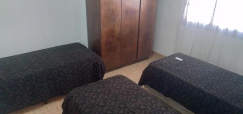 Pokój z 2 łóżkami i drewnianą szafką w obiekcie Casa cercana al Estadio Madre de Ciudades w mieście Santiago del Estero