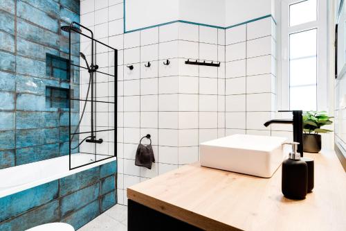 La salle de bains est pourvue d'un lavabo et d'une douche. dans l'établissement Apartament Plac Jana Pawła 7 Centrum Wrocław, à Wrocław