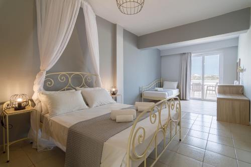 a bedroom with a large bed and a balcony at Hermes Hotel in Kefalos