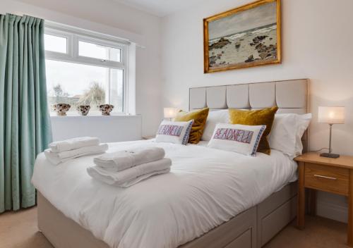 um quarto com uma grande cama branca com toalhas em Sandy Dell em Beadnell