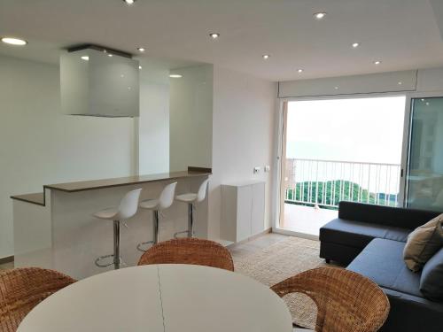 マルグラット・デ・マルにあるRECONNECTAR Malgrat de Mar Garbí Iのソファとテーブルと椅子のあるリビングルーム