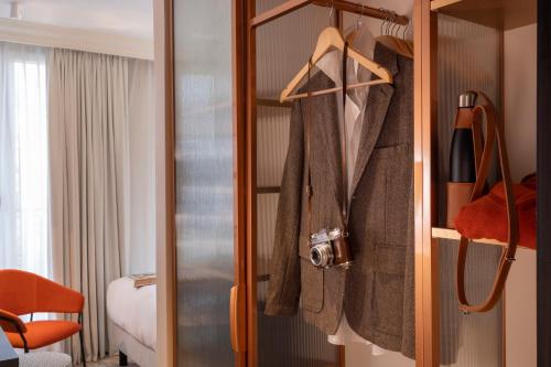 a room with a closet with coats and a bed at Alberte Hôtel in Paris