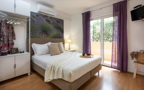um quarto com uma cama e uma grande janela em Apartments Sunny Elza em Hvar