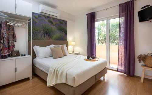 a bedroom with a bed and a large window at Apartments Sunny Elza in Hvar
