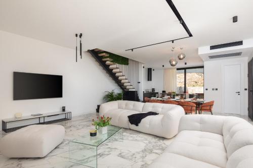uma sala de estar com dois sofás brancos e uma televisão em Luxury Villa Ander with Pool em Kostrena
