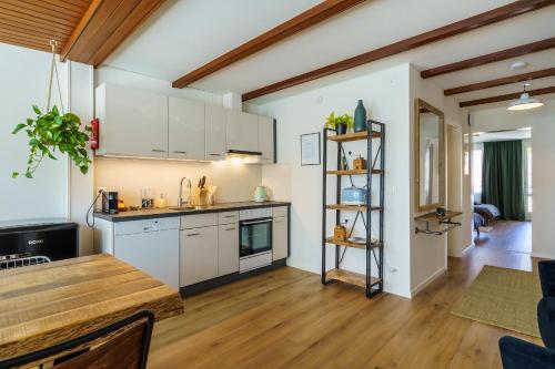 a kitchen with white cabinets and a wooden floor at Heart of Interlaken Apartments in Interlaken