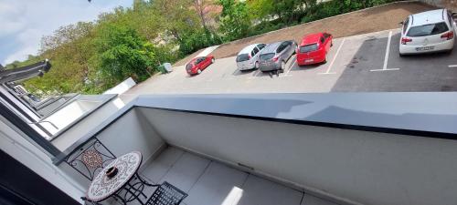 two pictures of cars parked in a parking lot at Lux Apartmani Novi Park in Vrdnik