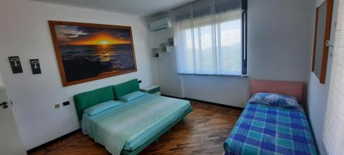 a bedroom with a green bed and a window at La Terrazza Casa Vacanza in Carenno