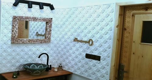 ein Badezimmer mit einem Waschbecken und einem Spiegel an der Wand in der Unterkunft Dar Yan in Er Rachidia
