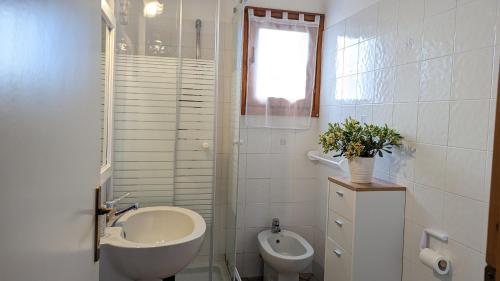bagno bianco con lavandino e servizi igienici di Porto Coda Cavallo - Salina Bamba a San Teodoro