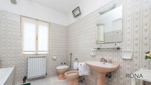 łazienka z umywalką, toaletą i lustrem w obiekcie Rona Apartments Ani w mieście Ičići