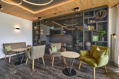 a lobby with chairs and tables in a room at Hotel Lindenhof in Kellberg