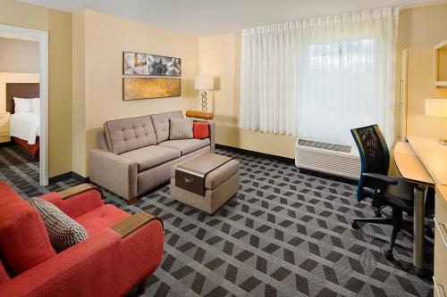 um quarto de hotel com um sofá e uma cama em TownePlace Suites by Marriott Fayetteville N / Springdale em Johnson