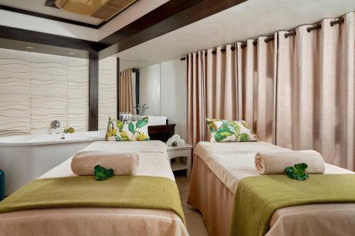Protea Hotel by Marriott Midrand في ميدراند: غرفة بسريرين عليها مناشف