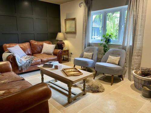 uma sala de estar com um sofá, uma mesa e cadeiras em Beautiful 3 bed cottage in Lymington. Perfectly located for Coast and New Forest em Lymington