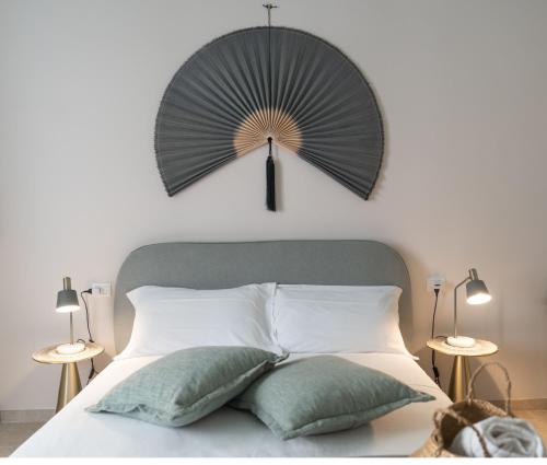 a bedroom with a bed with a fan on the wall at Palazzo Marzionna in Polignano a Mare