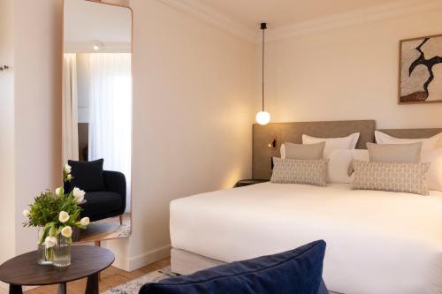 a bedroom with a bed and a chair and a table at Alberte Hôtel in Paris