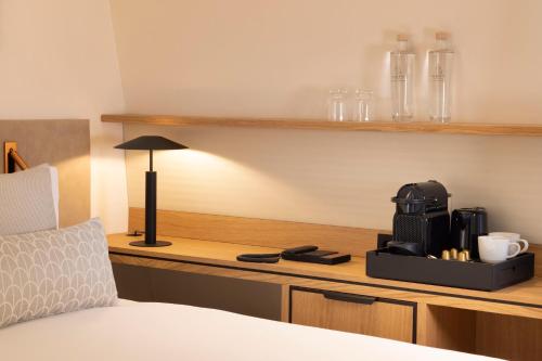 a room with a bed with a coffee maker on a desk at Alberte Hôtel in Paris
