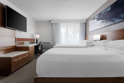 a hotel room with two beds and a desk at Delta Hotels by Marriott Burlington in Burlington