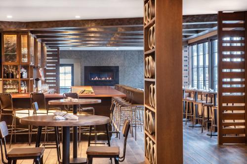 a restaurant with tables and chairs and a fireplace at Delta Hotels by Marriott Burlington in Burlington