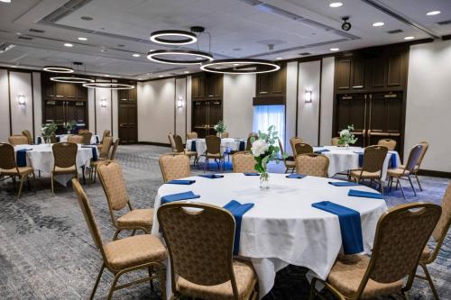 a conference room with tables and chairs with blue napkins at Delta Hotels by Marriott Burlington in Burlington