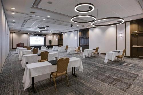 a conference room with tables and chairs and a projection screen at Delta Hotels by Marriott Burlington in Burlington