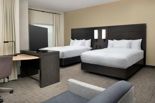 a hotel room with two beds and a desk at Residence Inn Doral Mall Area in Doral