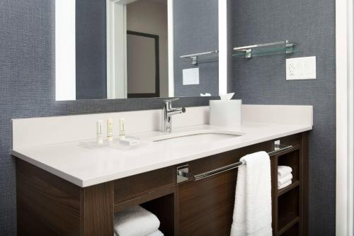 a bathroom with a sink and a mirror at Residence Inn Doral Mall Area in Doral