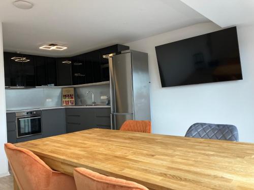 a kitchen with a wooden table and a television on the wall at MEINpartments Wolfsburg in Wolfsburg