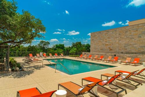 a swimming pool with lounge chairs and a building at Sheraton Austin Georgetown Hotel & Conference Center in Georgetown