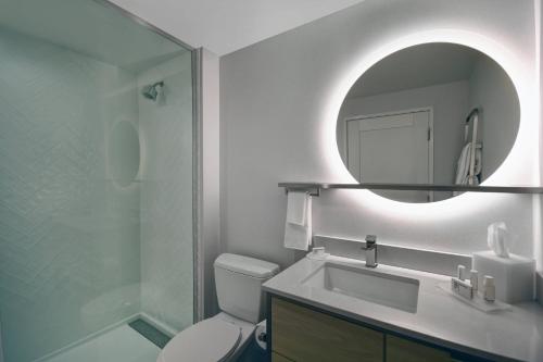 a bathroom with a toilet and a sink and a mirror at TownePlace Suites by Marriott Fall River Westport in Lakeside