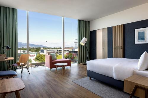 a hotel room with a bed and large windows at Four Points by Sheraton Panoramahaus Dornbirn in Dornbirn