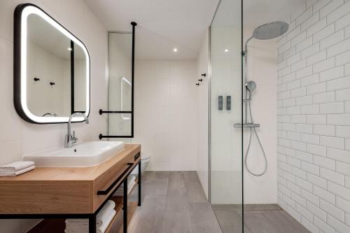 a bathroom with a sink and a shower at Four Points by Sheraton Panoramahaus Dornbirn in Dornbirn