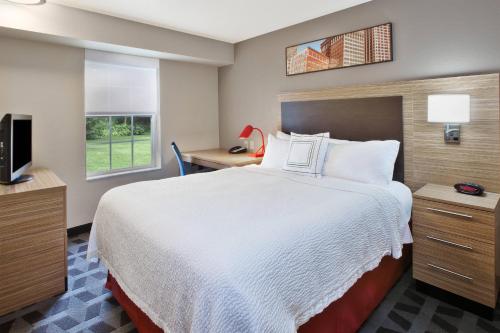 a hotel room with a bed and a television at TownePlace Suites by Marriott Brookfield in Brookfield