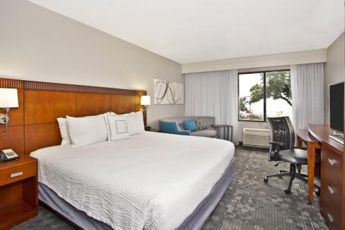 a hotel room with a bed and a desk at Courtyard by Marriott Gulfport Beachfront in Gulfport