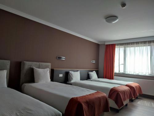 a hotel room with two beds and a window at Hotel Taormina Brussels Airport in Zaventem