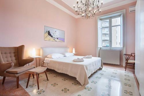 パレルモにあるKMC suites - Purpleのベッドルーム1室(ベッド1台、椅子、シャンデリア付)