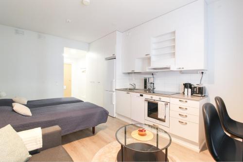 a living room with a bed and a kitchen at City Apartment Myllyntupa in Kuopio
