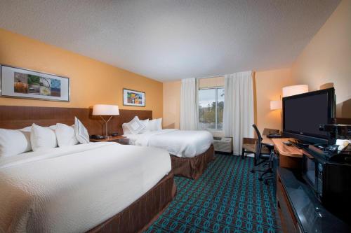 Habitación de hotel con 2 camas, escritorio y TV. en Fairfield Inn and Suites Charleston North/University Area, en Charleston