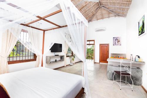 a bedroom with a bed and a tv in a room at Halcyon Galle in Galle
