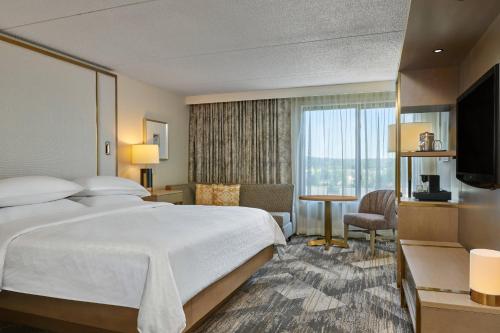um quarto de hotel com uma cama e uma televisão em Sheraton Portland Airport Hotel em Portland