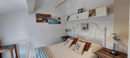a bedroom with a white bed with pillows on it at Villa T3 à 10' de Cassis - Piscine privée et cuisine d'été extérieure in Carnoux