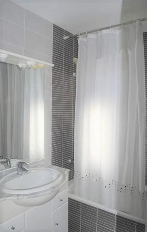 a bathroom with a sink and a shower curtain at Villa Cala Llobeta 4C-11 in Calafat