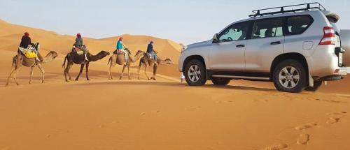 a group of people riding camels in the desert at Dar El Sultan Tozeur in Tozeur