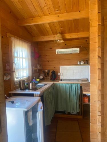 a kitchen in a log cabin with a sink and a stove at Cabaña abundancia in El Palmar