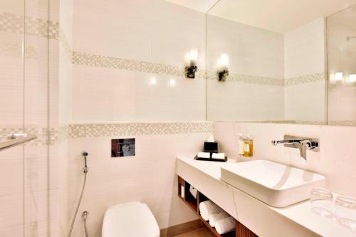 a white bathroom with a sink and a toilet at Fairfield by Marriott Jodhpur in Jodhpur