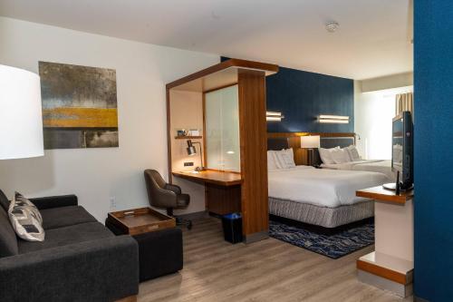 um quarto de hotel com uma cama e um sofá em SpringHill Suites by Marriott Houston Baytown em Baytown