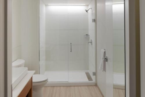 uma casa de banho branca com um chuveiro e um WC. em Element Asheville Downtown em Asheville